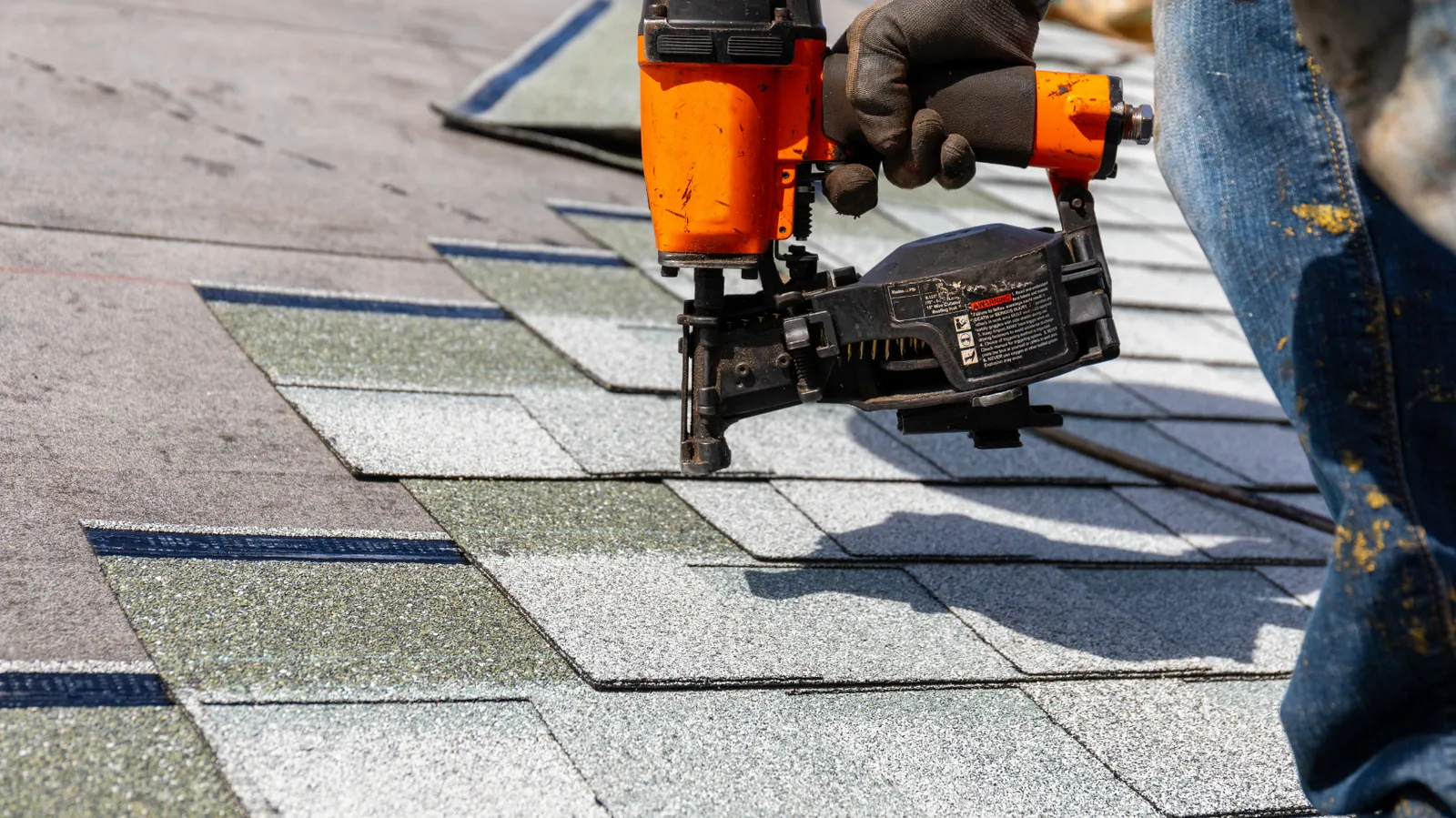 Nails driven into new roof shingles by a pneumatic nailer